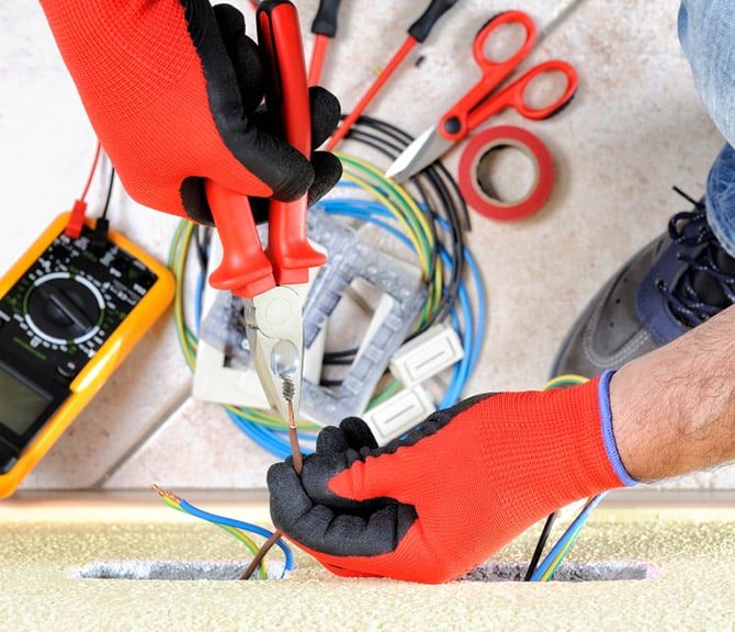 Electrician Holding Pliers and Wire — Jayden Enterprises in Mackay, QLD