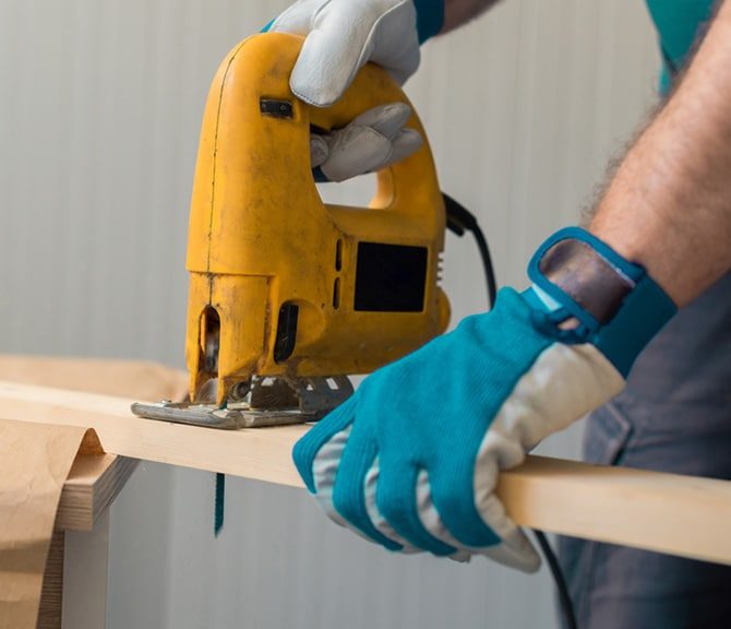 Carpenter Holding Saw Machine — Jayden Enterprises in Mackay, QLD
