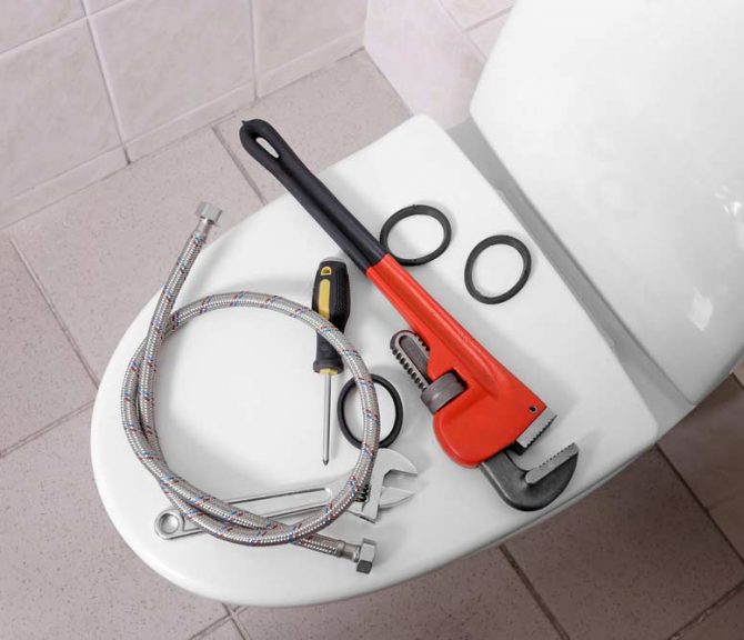 Plumber's Tools On Toilet At Home