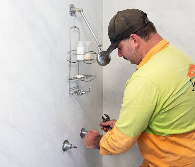 Man Doing Plumbing Maintenance in Bathroom